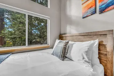 a bedroom with a bed with a large window at Kings Beach Retreat Hot Tub & Game Loft in Kings Beach