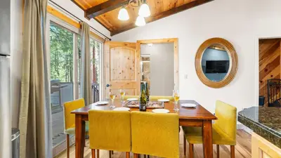 a dining room with a wooden table and yellow chairs at Steps to Trails Minutes to Heavenly Fireplace Deck BBQ Bluewood Cabin by AvantStay in South Lake Tahoe