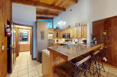a kitchen with wooden cabinets and a island with a counter top at Chateau Sans Nom 12 in Mammoth Lakes
