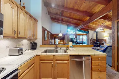 a kitchen with wooden cabinets and a stainless steel sink at Chateau Sans Nom 12 in Mammoth Lakes