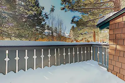 a fence covered in snow next to a house at Chateau Sans Nom 11 in Mammoth Lakes