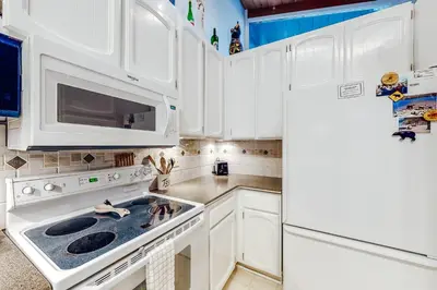 a kitchen with white cabinets and a stove and a refrigerator at Chateau Sans Nom 9 in Mammoth Lakes
