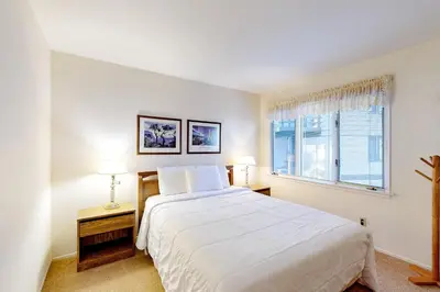 a white bedroom with a large bed and two windows at Chateau Sans Nom 9 in Mammoth Lakes