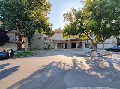a street in front of a house with a tree at Rancho Cordova Inn in Rancho Cordova