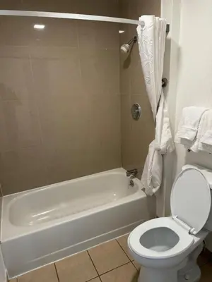 a bathroom with a white tub and a toilet at Rancho Cordova Inn in Rancho Cordova