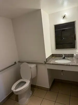 a bathroom with a toilet and a sink at Rancho Cordova Inn in Rancho Cordova