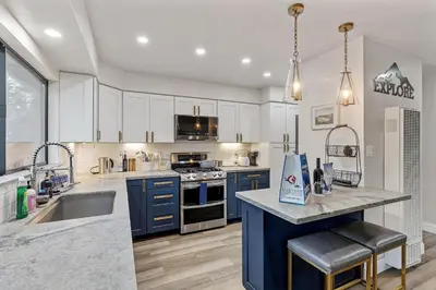 a kitchen with white cabinets and a blue island at CYH0883- Patricia's Mountain Paradise home in South Lake Tahoe