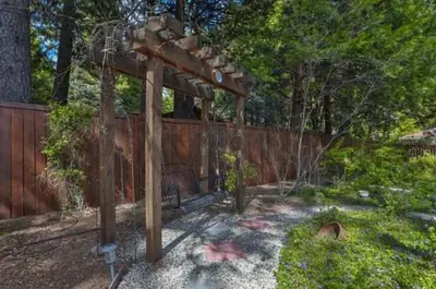 a wooden pergola with a bench in a yard at Country Style Mountain Home - View of Lake Forebay in Pollock Pines