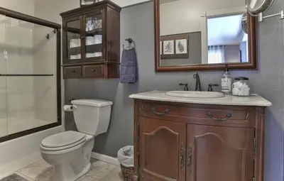 a bathroom with a toilet and a sink and a mirror at Country Style Mountain Home - View of Lake Forebay in Pollock Pines