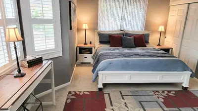 a bedroom with a large bed and two windows at Country Style Mountain Home - View of Lake Forebay in Pollock Pines