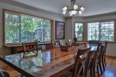 a dining room with a large wooden table and chairs at Country Style Mountain Home - View of Lake Forebay in Pollock Pines