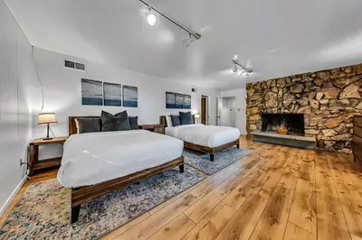a bedroom with two beds and a stone fireplace at Peaceful Forest Retreat Near Lake and Town in Tahoe City