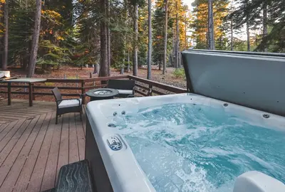 a hot tub on a deck with a table and chairs at Iroquois Ridge Hot Tub Near Lake Tahoe & Skiing in South Lake Tahoe