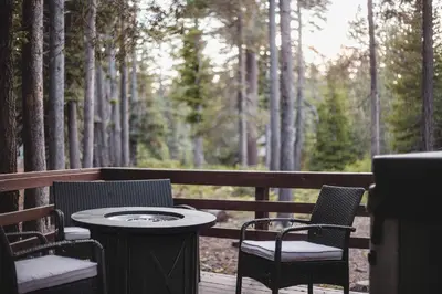 a table and chairs on a deck with trees at Iroquois Ridge Hot Tub Near Lake Tahoe & Skiing in South Lake Tahoe