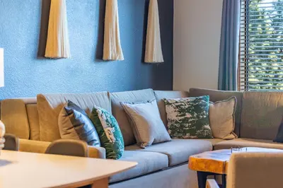 a living room with a couch with pillows on it at Posh Village 2/2; Ski-In/Out + Premiere Perks! in Mammoth Lakes