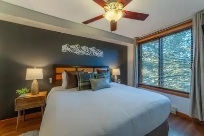 a bedroom with a large bed and a ceiling fan at Posh Village 2/2; Ski-In/Out + Premiere Perks! in Mammoth Lakes
