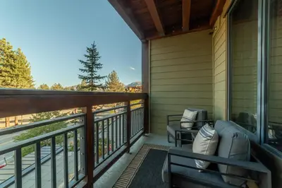 a screened in porch with a couch and chairs on it at Posh Village 2/2; Ski-In/Out + Premiere Perks! in Mammoth Lakes