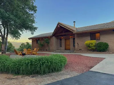 a house with a table and chairs in front of it at NEW LISTING, Near Yosemite South Gate entrance and town, King bed, Hot Tub, BBQ, Firepit & Mountain Views in Oakhurst