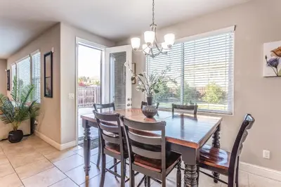 a dining room with a wooden table and chairs at Nic's Home in Visalia