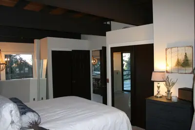 a bedroom with a bed and a dresser with a lamp at Modern Rustic Lux Tahoe Cabin in Carnelian Bay