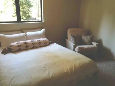 a bedroom with a bed with a pillow and a chair at Modern Rustic Lux Tahoe Cabin in Carnelian Bay