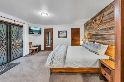 a bedroom with a large bed with a wooden headboard at Wooded Getaway Steam Shower plus Hot Tub in Tahoe City