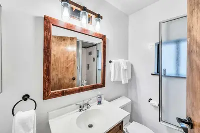 a white bathroom with a sink and a mirror at Wooded Getaway Steam Shower plus Hot Tub in Tahoe City