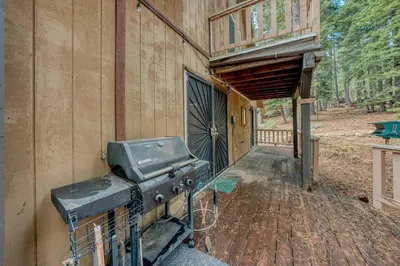 a grill on the side of a building with a porch at Wooded Getaway Steam Shower plus Hot Tub in Tahoe City