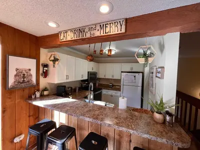 a kitchen with a counter with stools in it at Cozy Walk-to-Lifts Mammoth Condo with Hot Tub in Mammoth Lakes