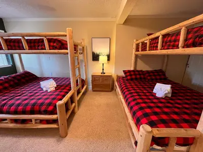 a bedroom with two bunk beds and a lamp at Cozy Walk-to-Lifts Mammoth Condo with Hot Tub in Mammoth Lakes