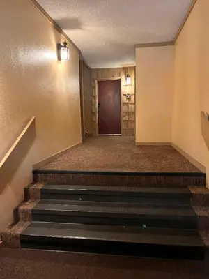 a hallway with stairs leading to a door at Cozy Walk-to-Lifts Mammoth Condo with Hot Tub in Mammoth Lakes