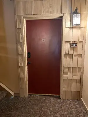a brown door in a room with a brick wall at Cozy Walk-to-Lifts Mammoth Condo with Hot Tub in Mammoth Lakes