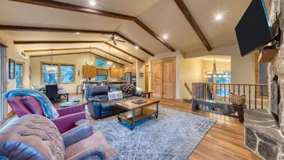 a living room with a couch and a table at Cozy Tahoe Retreat w Hot Tub Movie Room Forest Views 10th ave 2 by AvantStay in Tahoma