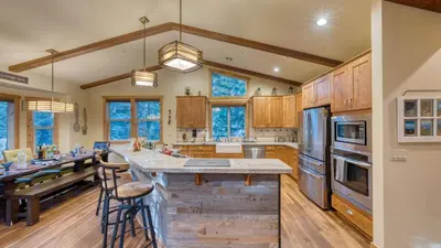 a kitchen with wooden cabinets and stainless steel appliances at Cozy Tahoe Retreat w Hot Tub Movie Room Forest Views 10th ave 2 by AvantStay in Tahoma
