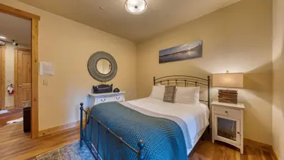 a bedroom with a bed and a mirror at Cozy Tahoe Retreat w Hot Tub Movie Room Forest Views 10th ave 2 by AvantStay in Tahoma