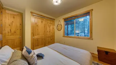 a bedroom with a bed and a window at Cozy Tahoe Retreat w Hot Tub Movie Room Forest Views 10th ave 2 by AvantStay in Tahoma