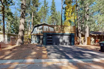 a house with a garage in the woods at The Pine Chalet in South Lake Tahoe