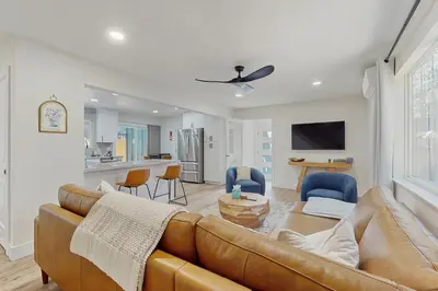 a living room with a brown couch and a kitchen at The Pine Chalet in South Lake Tahoe