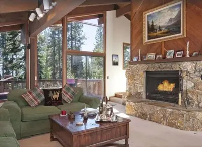a living room with a fireplace and a green couch at Dollar Point for 10-Hot Tub-One Block to the Beach-Filtered Lake Views-Quiet Neighborhood in Tahoe City