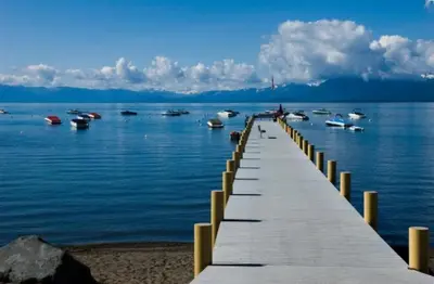 a wooden pier with boats in the water at Dollar Point for 10-Hot Tub-One Block to the Beach-Filtered Lake Views-Quiet Neighborhood in Tahoe City