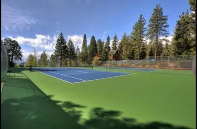 a tennis court with trees in the background at Dollar Point for 10-Hot Tub-One Block to the Beach-Filtered Lake Views-Quiet Neighborhood in Tahoe City