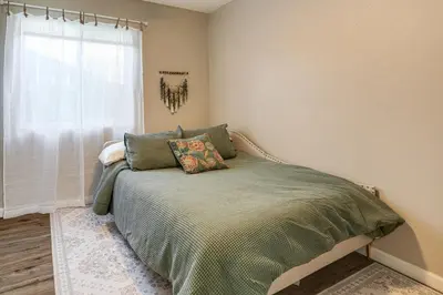 a bed in a bedroom with a window at Couples Retreat! Shop, Dine, Explore Dtwn Oakdale in Oakdale