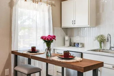 a kitchen with a table with flowers on it at Couples Retreat! Shop, Dine, Explore Dtwn Oakdale in Oakdale