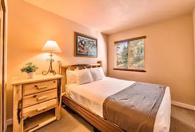 a bedroom with a bed and a table with a lamp at Galaxy Way Close to Stagecoach Chair in Stateline