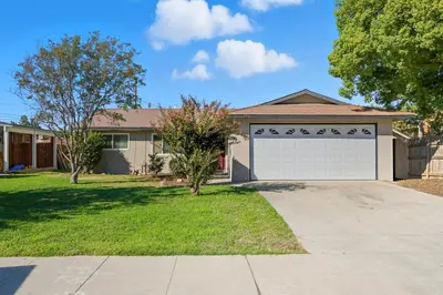 a house with a driveway and a garage at The Cozy Rustic Sequoia Wi-Fi & 2 Garage in Tulare