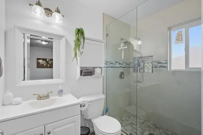 a bathroom with a shower and a toilet and a sink at The Cozy Rustic Sequoia Wi-Fi & 2 Garage in Tulare