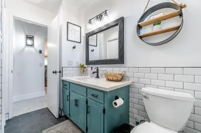 a bathroom with a toilet and a sink and a mirror at OctaFarmRetreat - Gateway To Sequoia Natl Park in Visalia