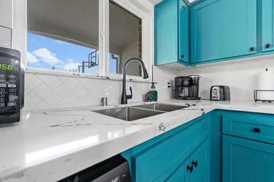a kitchen with blue cabinets and a sink at Cambridge Corner - Gateway to Sequoia Ntl Park in Visalia
