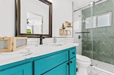 a bathroom with a blue vanity and a shower at Cambridge Corner - Gateway to Sequoia Ntl Park in Visalia