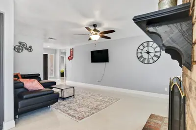 a living room with a couch and a clock on the wall at The Royal Oak Splash Sequoia Nat'l Park Lake Mts in Visalia